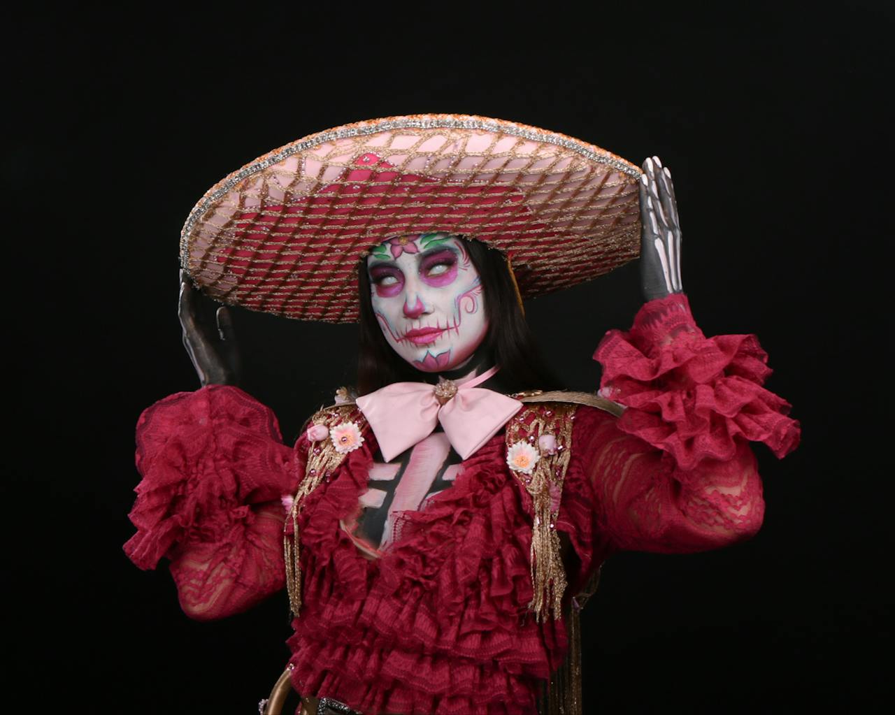 A creative Day of the Dead costume featuring a skeleton face and vibrant attire.